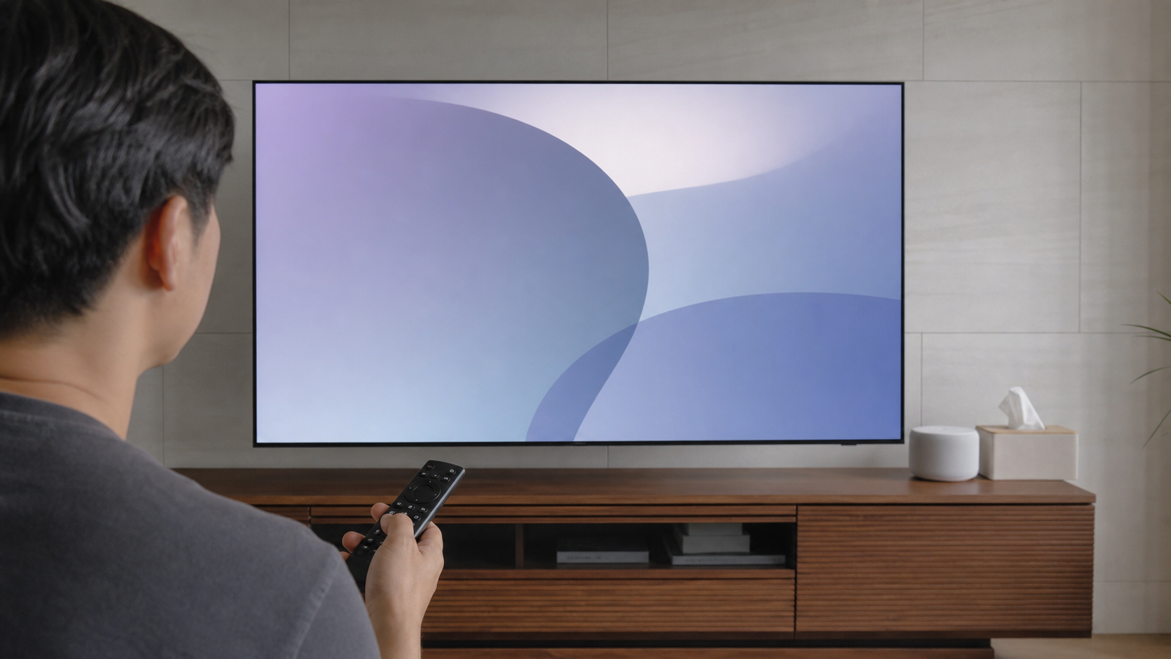 거실에서 OLED TV 리모컨으로 화면 보호와 전원 관련 메뉴를 확인하는 모습